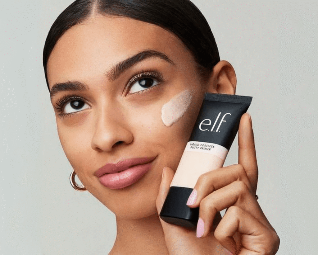 Woman applying e.l.f. Liquid Poreless Putty Primer to her cheek, demonstrating its smooth, pore-blurring effect, ideal for a TikTok beauty finds 2025 makeup tutorial or review.